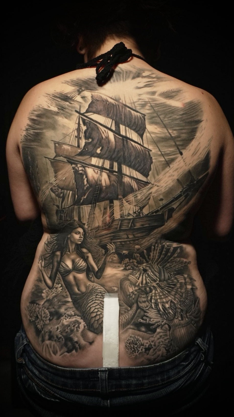 Black and grey realism full back piece with ship and mermaid